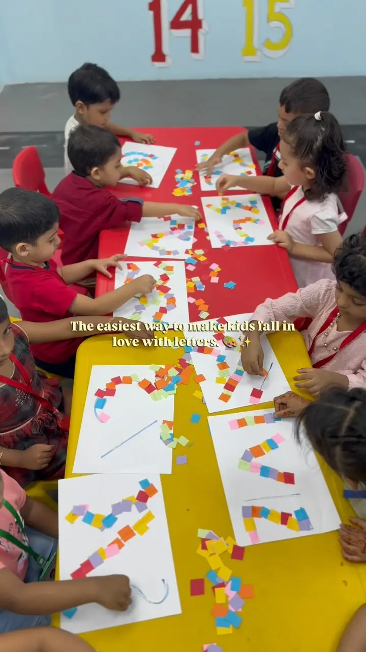 Children sticking coloured paper squares onto shape outlines