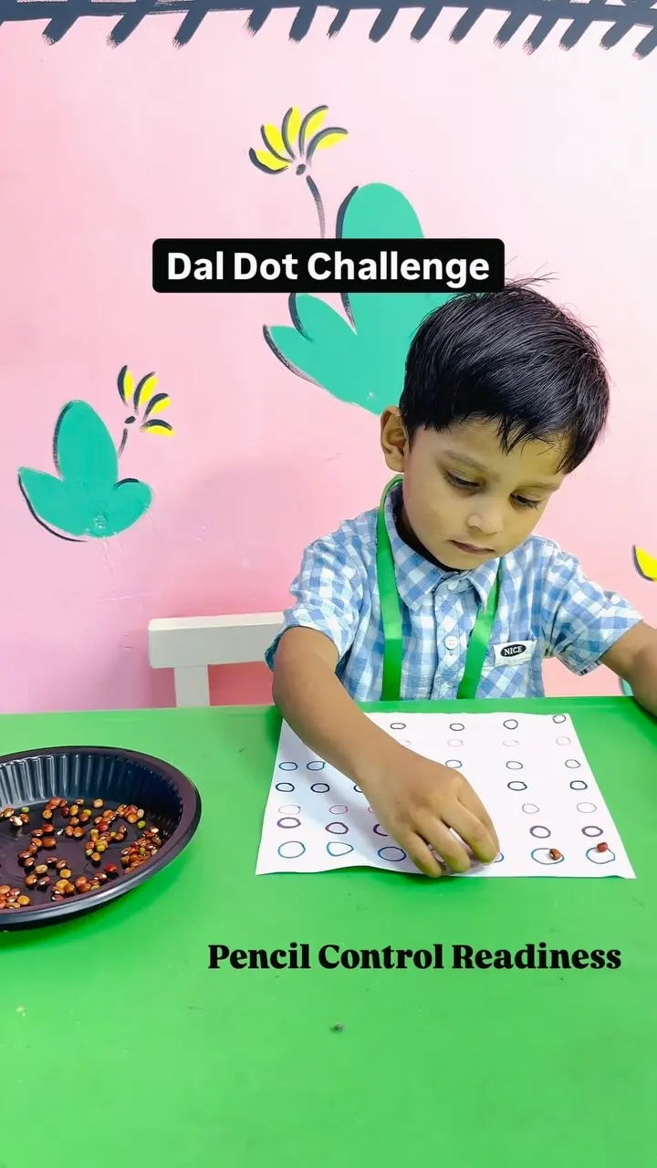 A child placing lentils on a dotted pencil-control worksheet
