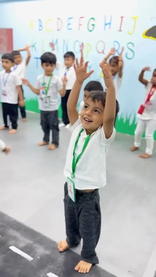 Children stretching their arms up during a laughing-yoga session