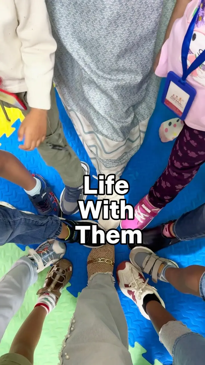 Children and teachers standing in a circle on the foam play mats