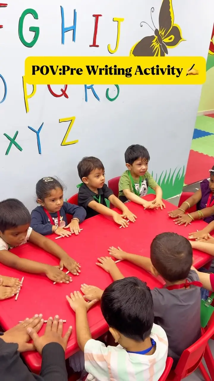 Children arranging sticks on paper in a pre-writing activity