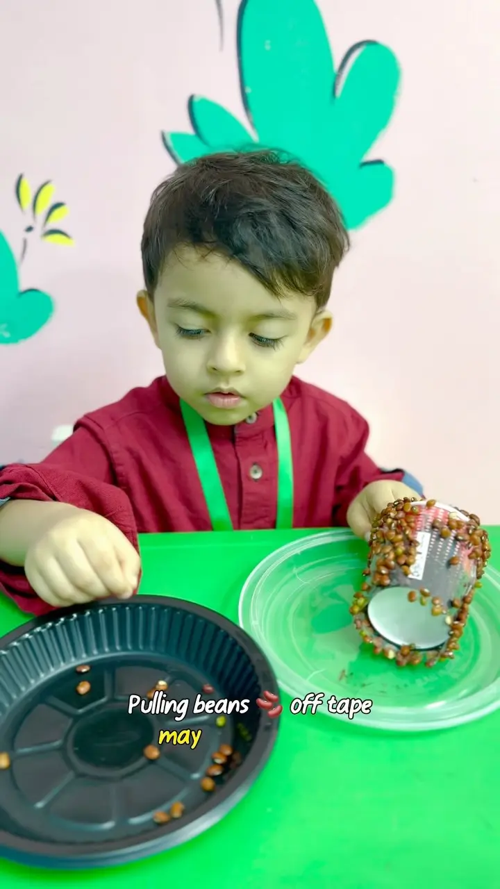 A child peeling seeds off sticky tape to practise finger control