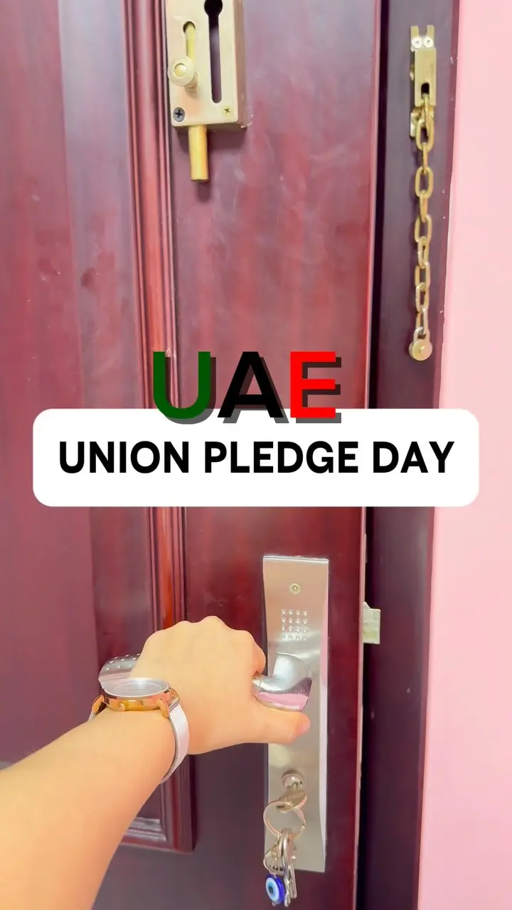 Children in kanduras holding UAE flags on Union Pledge Day
