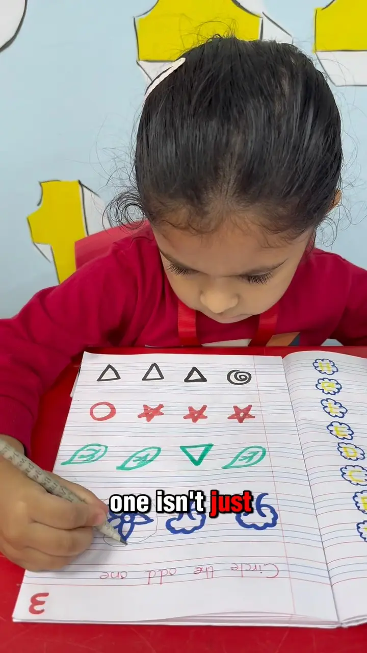 A child tracing shapes on an English worksheet